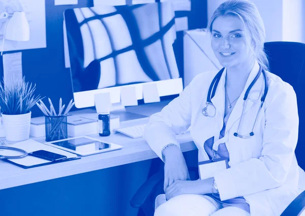 병원 책상에 앉아 있는 젊은 여성 의사의 모습 — 스톡 사진
