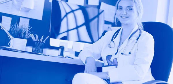 Portret van een jonge vrouwelijke arts aan het bureau in het ziekenhuis — Stockfoto
