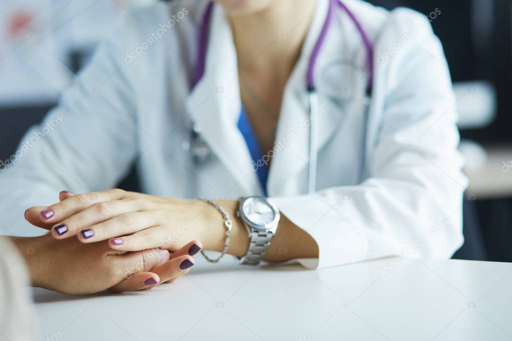 Woman doctor helping senior holding hand in hospital