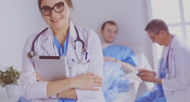 Hastane lobisinde tablet bilgisayar kullanan kadın doktor.