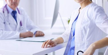 Hastanedeki danışma odasında gülümseyen iki doktor.