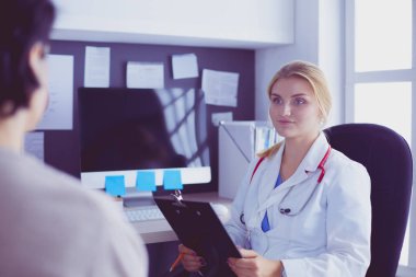 Kadın doktor, kadın hastasına teşhisi açıklıyor.