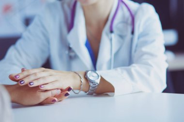 Kadın doktor yaşlılara hastanede el ele tutuşmalarında yardım ediyor