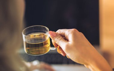 Kredi kartı tutan ve dizüstü bilgisayar kullanan genç bir kadın. Çevrimiçi alışveriş kavramı