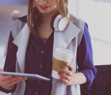 Ofis masasında çalışan ve dizüstü bilgisayarla yazan kendine güvenen genç bir iş kadını.