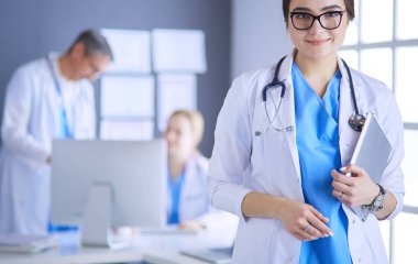 Hastane lobisinde tablet bilgisayar kullanan kadın doktor.