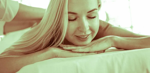 Piękna młoda kobieta leżąca w salonie spa — Zdjęcie stockowe