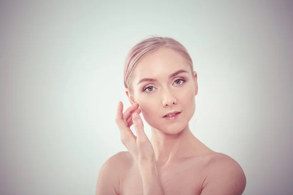 Das schöne junge Mädchen mit sauberer, frischer Haut berührt mit der Hand eine Wange — Stockfoto