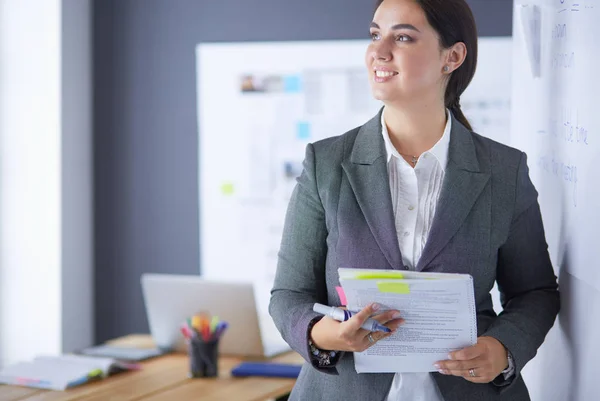 Business, formazione e concetto di ufficio - team di lavoro con flip board in ufficio discutendo di qualcosa. — Foto Stock