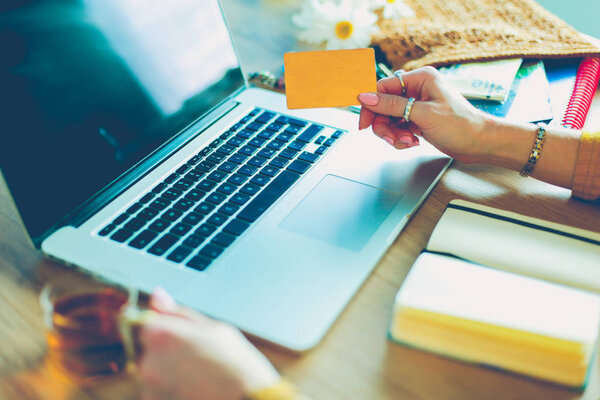 Young woman holding credit card and using laptop computer. Online shopping concept