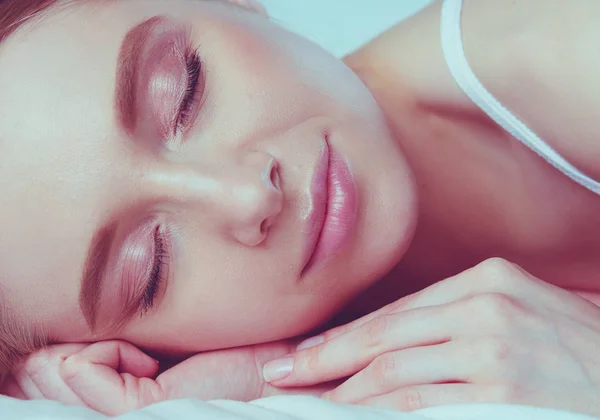 Foto van slapende jonge vrouw liggend in bed met gesloten ogen — Stockfoto