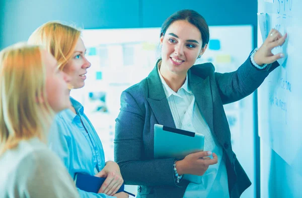 Concepto de negocio, educación y oficina - equipo de negocios con flip board en la oficina discutiendo algo. —  Fotos de Stock