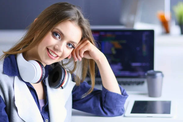 Ofis masasında çalışan ve dizüstü bilgisayarla yazan kendine güvenen genç bir iş kadını. — Stok fotoğraf