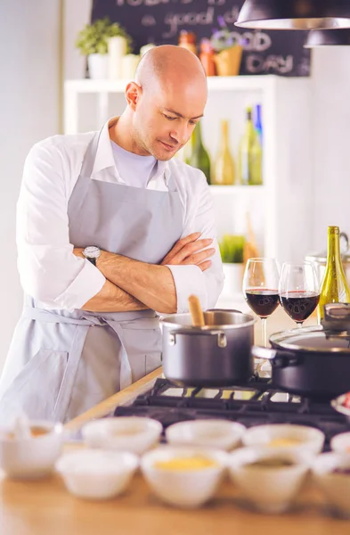 Handsome man is cooking on kitchen and smiling