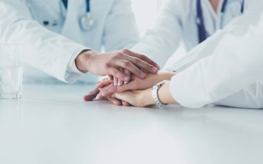 Doktorlar el ele tutuşup yakın çekim yapıyor.