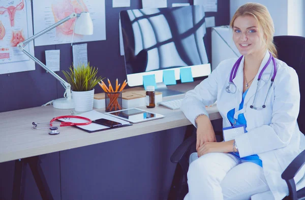 Προσωπογραφία νεαρής γυναίκας γιατρού που κάθεται στο γραφείο στο νοσοκομείο — Φωτογραφία Αρχείου