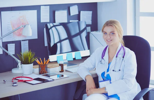 Retrato de uma jovem médica sentada à mesa no hospital — Fotografia de Stock