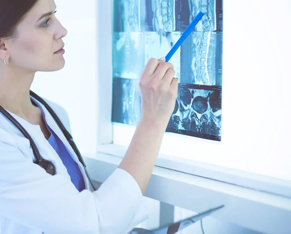 Stetoskop lu genç gülümseyen kadın doktor doktor ofisinde röntgeni işaret ediyor — Stok fotoğraf