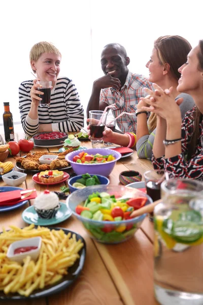 Vista superior do grupo de pessoas que jantam juntas enquanto estão sentadas à mesa de madeira. Comida na mesa. As pessoas comem fast food. — Fotografia de Stock