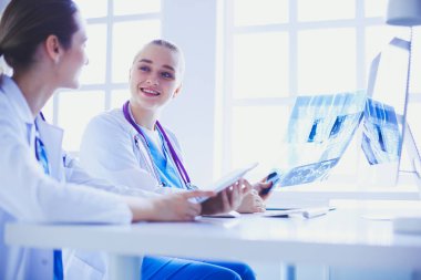 Hastanede bilgisayarla çalışan iki genç bayan doktor..