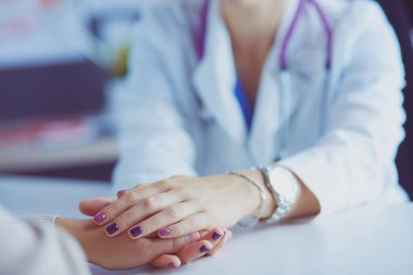 Kadın doktor yaşlılara hastanede el ele tutuşmalarında yardım ediyor