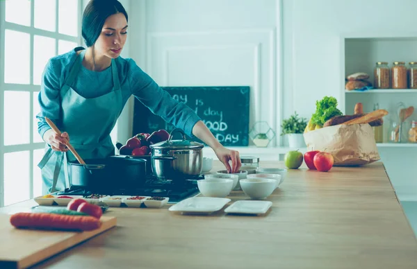 Koken vrouw in keuken met houten lepel — Stockfoto