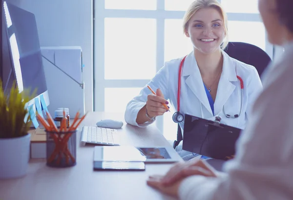 Female doctor holding application form while consulting patient — Stock Photo, Image