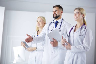 Meslektaşlarının önünde el sıkışan bir erkek doktor.