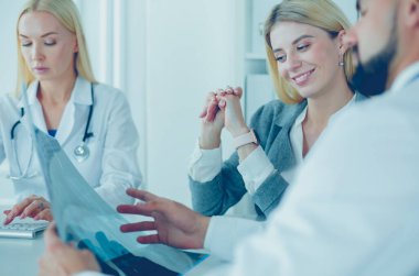 Doktor kadın hastanın göğüs röntgenini gösteriyor.