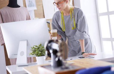 Moda tasarımcısı kadın dikiş makinesiyle dikiş dikiyor