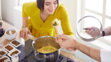 Evdeki mutfakta birlikte yemek pişiren çift.