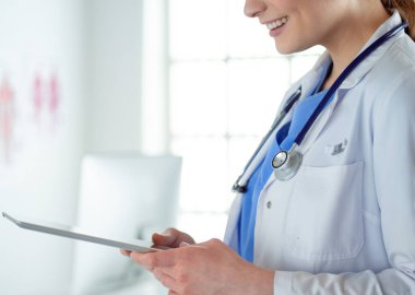 Hastane lobisinde tablet bilgisayar kullanan kadın doktor.