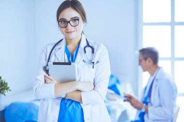 Hastane lobisinde tablet bilgisayar kullanan kadın doktor.