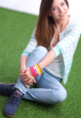 güzel bir kız bir arka planda yeşil doğanın bir parkta bankta oturan