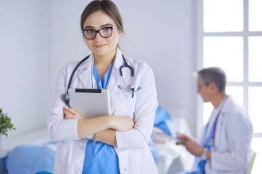 Hastane lobisinde tablet bilgisayar kullanan kadın doktor.