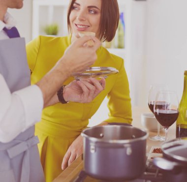 Evdeki mutfakta birlikte yemek pişiren çift.