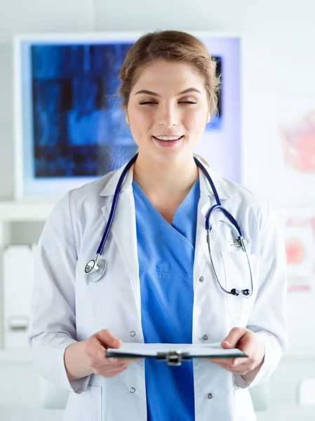 Woman doctor standing with folder at hospital — Stock Photo, Image