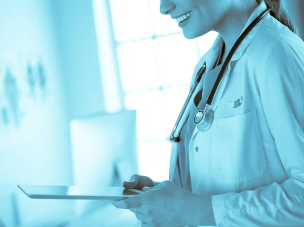 Female doctor using tablet computer in hospital lobby