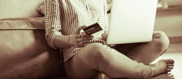 Hermosa mujer joven usando tarjeta de crédito y portátil para compras en línea — Foto de Stock