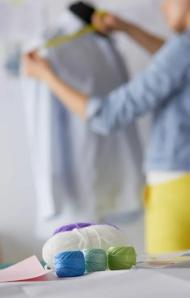 Young designer with tape is measuring white shirt — Stock Photo, Image