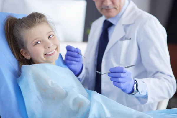 Niña sentada en el consultorio de dentistas — Foto de Stock