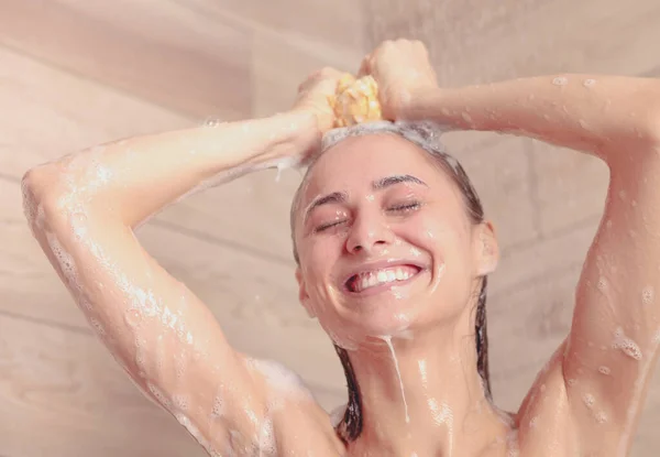 Joven mujer hermosa bajo la ducha en el baño . — Foto de Stock