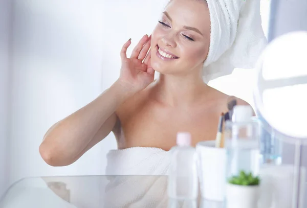 Giovane donna in accappatoio guardando nello specchio del bagno — Foto Stock