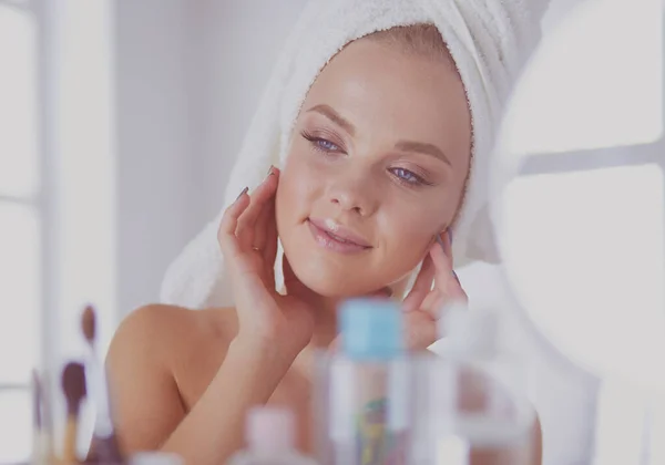 Bornozlu genç kadın banyo aynasına bakıyor. — Stok fotoğraf