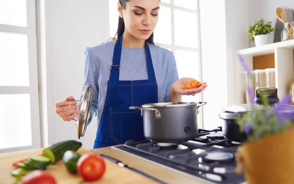 Cozinhar mulher na cozinha com colher de madeira — Fotografia de Stock