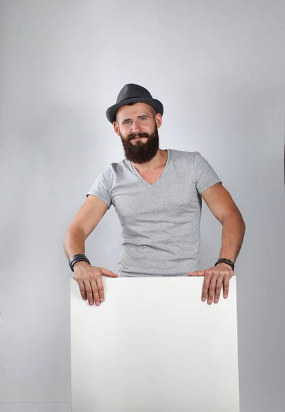 Retrato de un joven con sombrero de pie cerca del blanco, aislado sobre fondo blanco —  Fotos de Stock