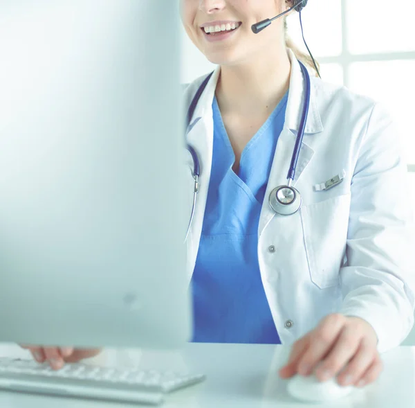 Joven médico practicante que trabaja en la recepción de la clínica, ella está respondiendo llamadas telefónicas y programando citas —  Fotos de Stock