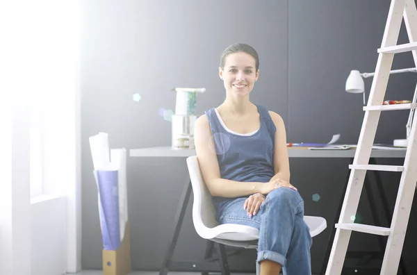 Giovane donna seduta alla scrivania con strumenti, piano e laptop. — Foto Stock