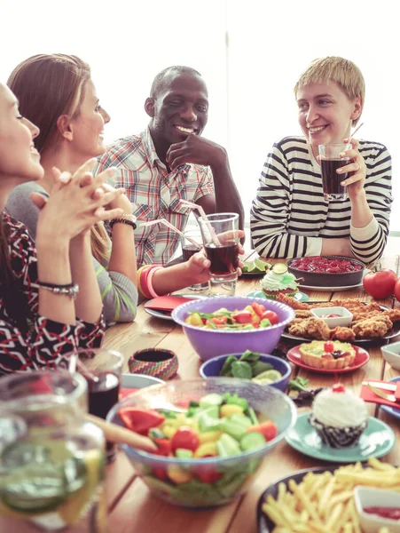 Vista superior do grupo de pessoas que jantam juntas enquanto estão sentadas à mesa de madeira. Comida na mesa. As pessoas comem fast food. — Fotografia de Stock