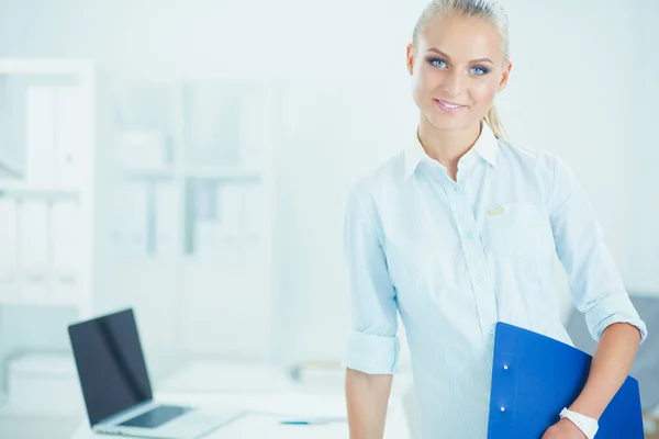 Portrait of smiling business woman with paper folder, standing in office — Stock Photo, Image